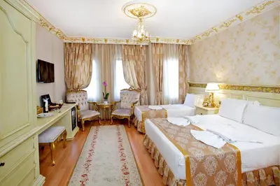 a hotel room with two beds and a desk at White House Hotel Istanbul in Istanbul
