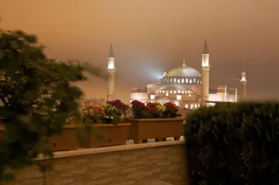 a building with a domed mosque in the fog at White House Hotel Istanbul in Istanbul