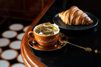 a cup of coffee and a croissant on a table at Park Hyatt Istanbul - Macka Palas in Istanbul