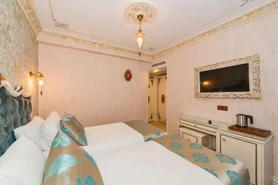 a hotel room with two beds and a tv at Hotel 1453 in Istanbul