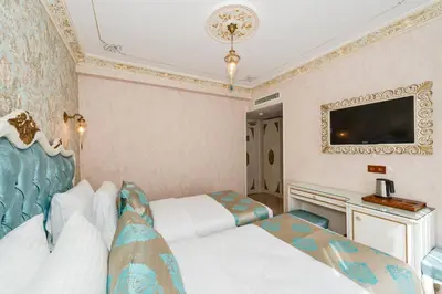 a hotel room with two beds and a flat screen tv at Hotel 1453 in Istanbul