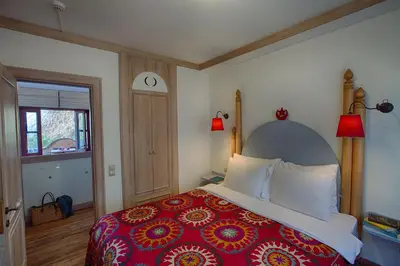 a bedroom with a large bed with a red bedspread at Hotel Empress Zoe in Istanbul
