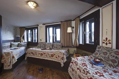 a bedroom with two beds and a couch and windows at Hotel Empress Zoe in Istanbul