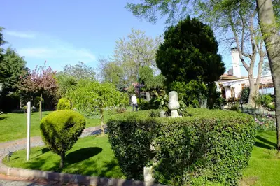 a garden with a statue in the middle of a bush at Turquhouse Hotel in Istanbul