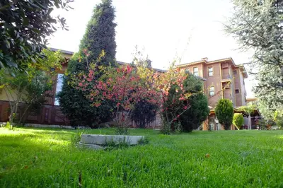 a yard in front of a house with trees and bushes at Turquhouse Hotel in Istanbul