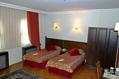a hotel room with two beds and red curtains at Turquhouse Hotel in Istanbul
