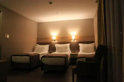 a hotel room with two beds and a chair at Regard Hotel in Istanbul