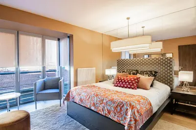 a bedroom with a bed and a blue chair at Deger 16 Residences in Istanbul