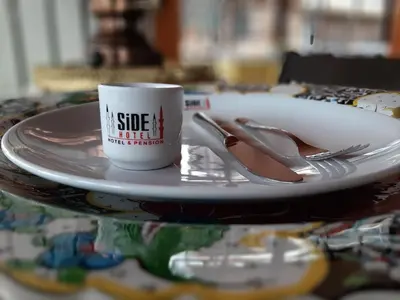 a plate with a coffee cup and a fork and knife at Side Hotel in Istanbul