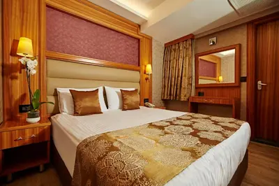 a hotel room with a large bed and a mirror at Ilkbal Deluxe Hotel &Spa Istanbul in Istanbul