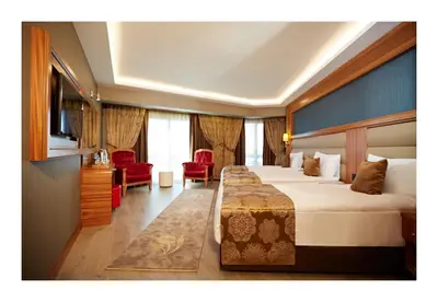 a hotel room with two beds and a television at Ilkbal Deluxe Hotel &Spa Istanbul in Istanbul