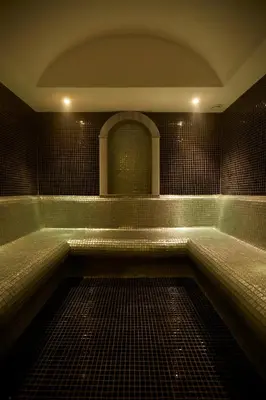 a bathroom with a tub with a tiled floor at Ilkbal Deluxe Hotel &Spa Istanbul in Istanbul