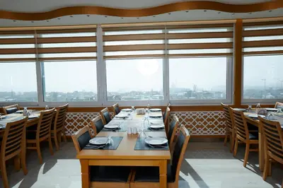 a dining room with tables and chairs and windows at Ilkbal Deluxe Hotel &Spa Istanbul in Istanbul