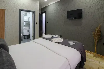a bedroom with a large white bed and a television at Nest HOTEL Sisli in Istanbul