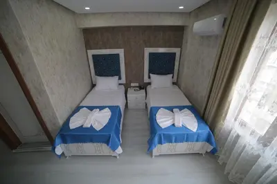 a room with two beds with blue and white covers at Hotel Aksaray istanbul in Istanbul