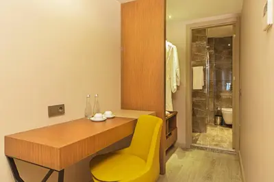 a bathroom with a desk and a yellow chair at Redmont Hotel Nisantasi in Istanbul