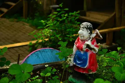 a statue of a boy holding a fish in a garden at Karaaslan Kamping Tesisleri in Kazandere