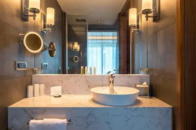 a bathroom with a sink and a large mirror at Golden Tulip Istanbul Bayrampasa in Istanbul