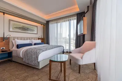 a hotel room with a bed and a chair at Golden Tulip Istanbul Bayrampasa in Istanbul