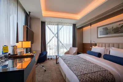 a hotel room with a bed and a desk at Golden Tulip Istanbul Bayrampasa in Istanbul