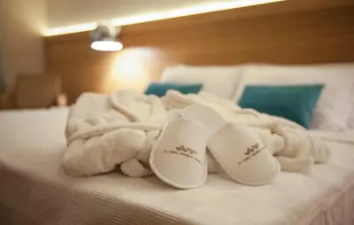 a bed with white towels and slippers on it at İstanbul Medikal Termal in Tuzla