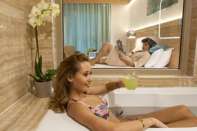 a woman sitting in a bath tub with a drink at İstanbul Medikal Termal in Tuzla
