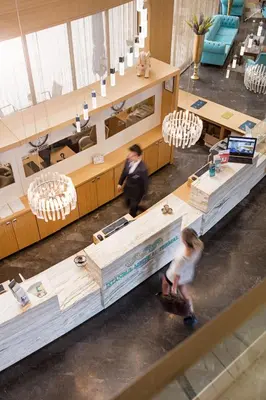 two people walking in a lobby with a table at İstanbul Medikal Termal in Tuzla