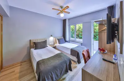 a hotel room with two beds and a tv at Palmada Hotel in Sakarya