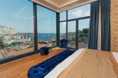 a bedroom with a large bed and large windows at Trip Bosphorus Taksim Hotel in Istanbul