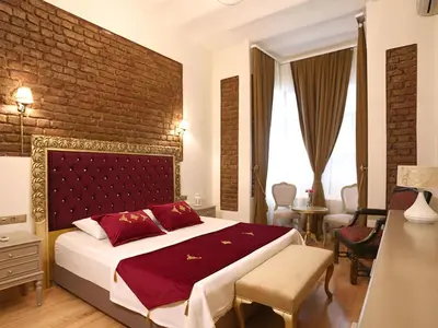 a bedroom with a large bed and a brick wall at Tepe Palace Hotel Taksim in Istanbul