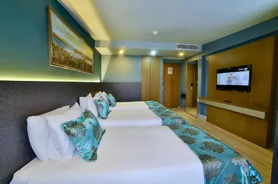 a hotel room with two beds and a flat screen tv at The Tango Hotel İstanbul in Istanbul
