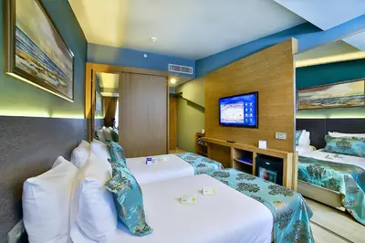 a hotel room with two beds and a flat screen tv at The Tango Hotel İstanbul in Istanbul