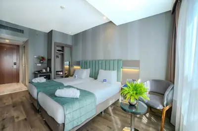 a hotel room with a large bed and a chair at The Tango Hotel İstanbul in Istanbul