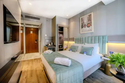 a bedroom with a large white bed with blue accents at The Tango Hotel İstanbul in Istanbul