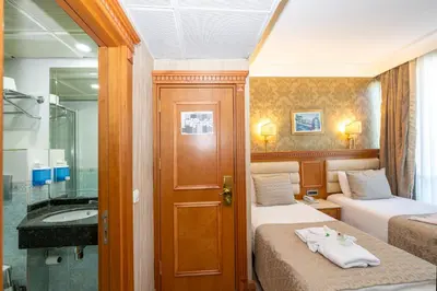 a small room with two beds and a bathroom at Dalan Otel in Istanbul