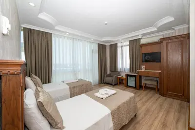 a hotel room with two beds and a desk at Dalan Otel in Istanbul
