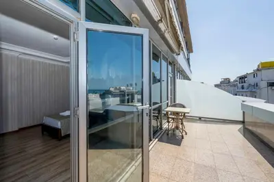 a balcony with glass doors and a table on a building at Dalan Otel in Istanbul