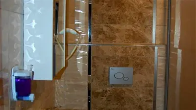 a glass of purple liquid sitting on a counter in a shower at Göznur Otel in Bandırma