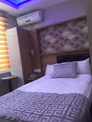 a bedroom with a white bed with a purple ceiling at Göznur Otel in Bandırma