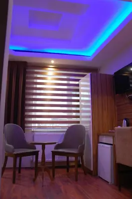 a room with two chairs and a table and a blue light at Göznur Otel in Bandırma