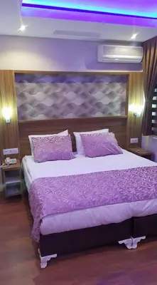 a bedroom with a large bed with purple sheets and pillows at Göznur Otel in Bandırma