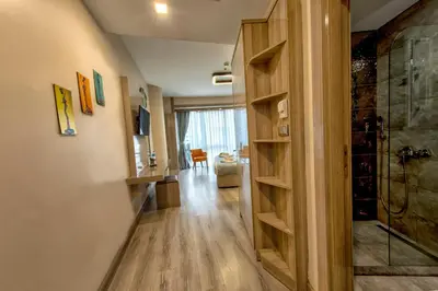 a hallway with a walk in shower and a wooden door at My House N5 Suites Hotel in Esenyurt