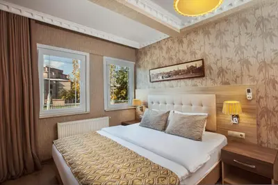 a bedroom with a large bed and two windows at Sultanahmet inn Hotel in Istanbul