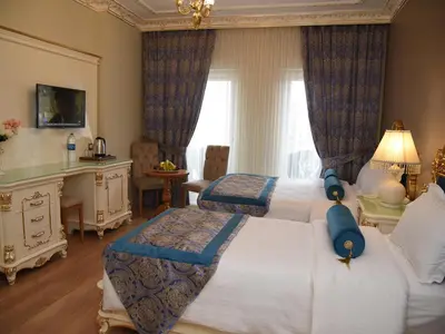 a bedroom with two beds and a desk and a television at İstasyon Hotel in Istanbul