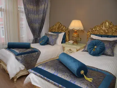a bedroom with two beds with blue pillows on them at İstasyon Hotel in Istanbul