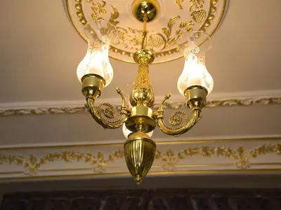 a gold chandelier hanging from a ceiling at İstasyon Hotel in Istanbul