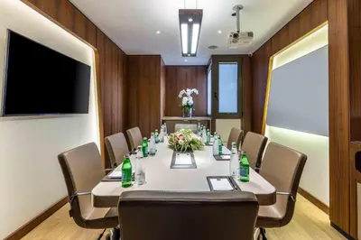 a conference room with a table and chairs and a television at Tzl Suites Hotel Nişantaşı in Istanbul