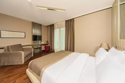 a hotel room with a large bed and a chair at The City Suites in Istanbul