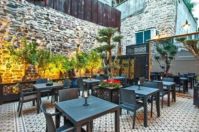a patio with tables and chairs and a brick wall at Ferman Konak Hotel-Special Category in Istanbul