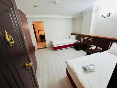 a hotel room with two beds and a door at Red White Hotel in Istanbul